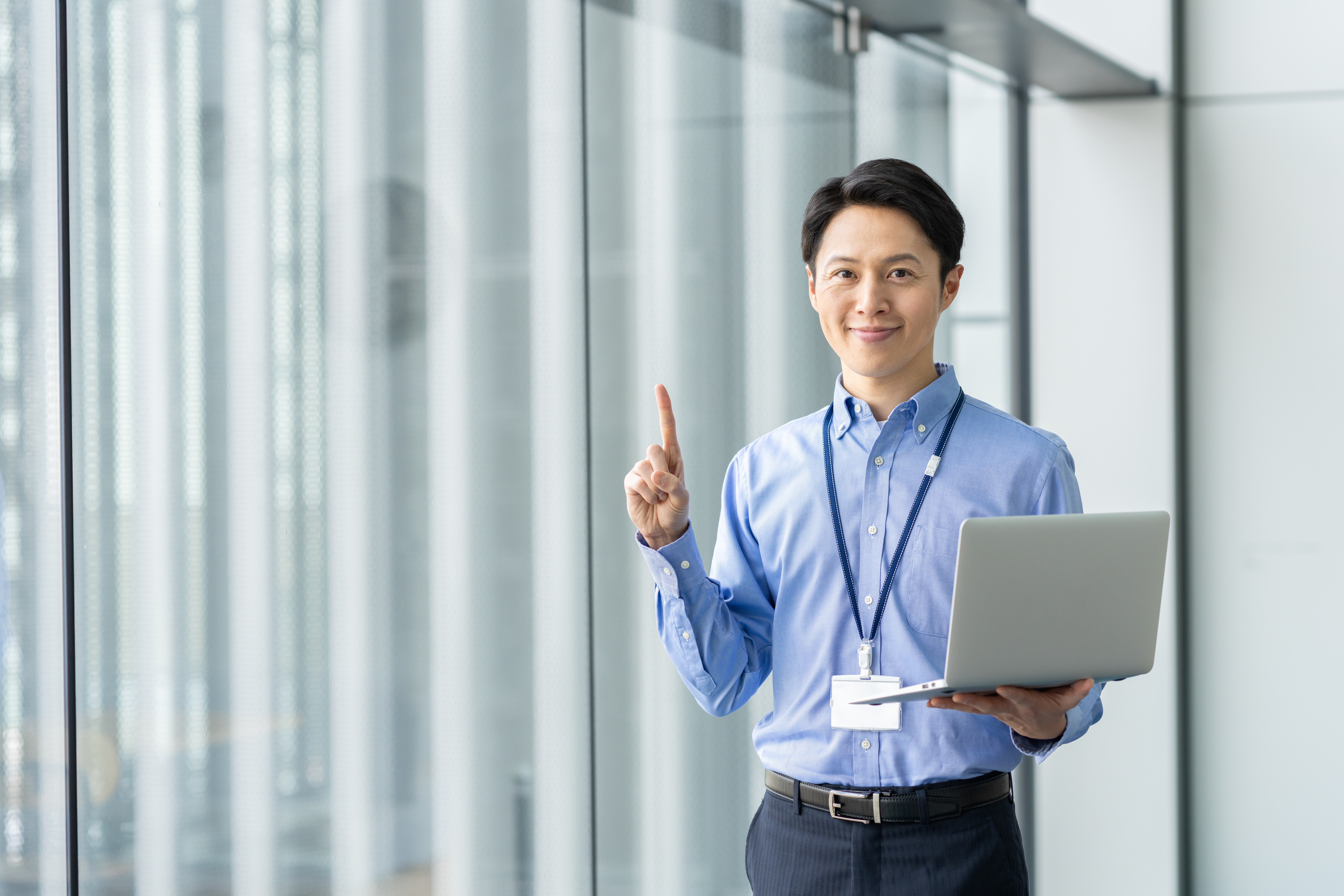 パソコンを持ち指さす男性