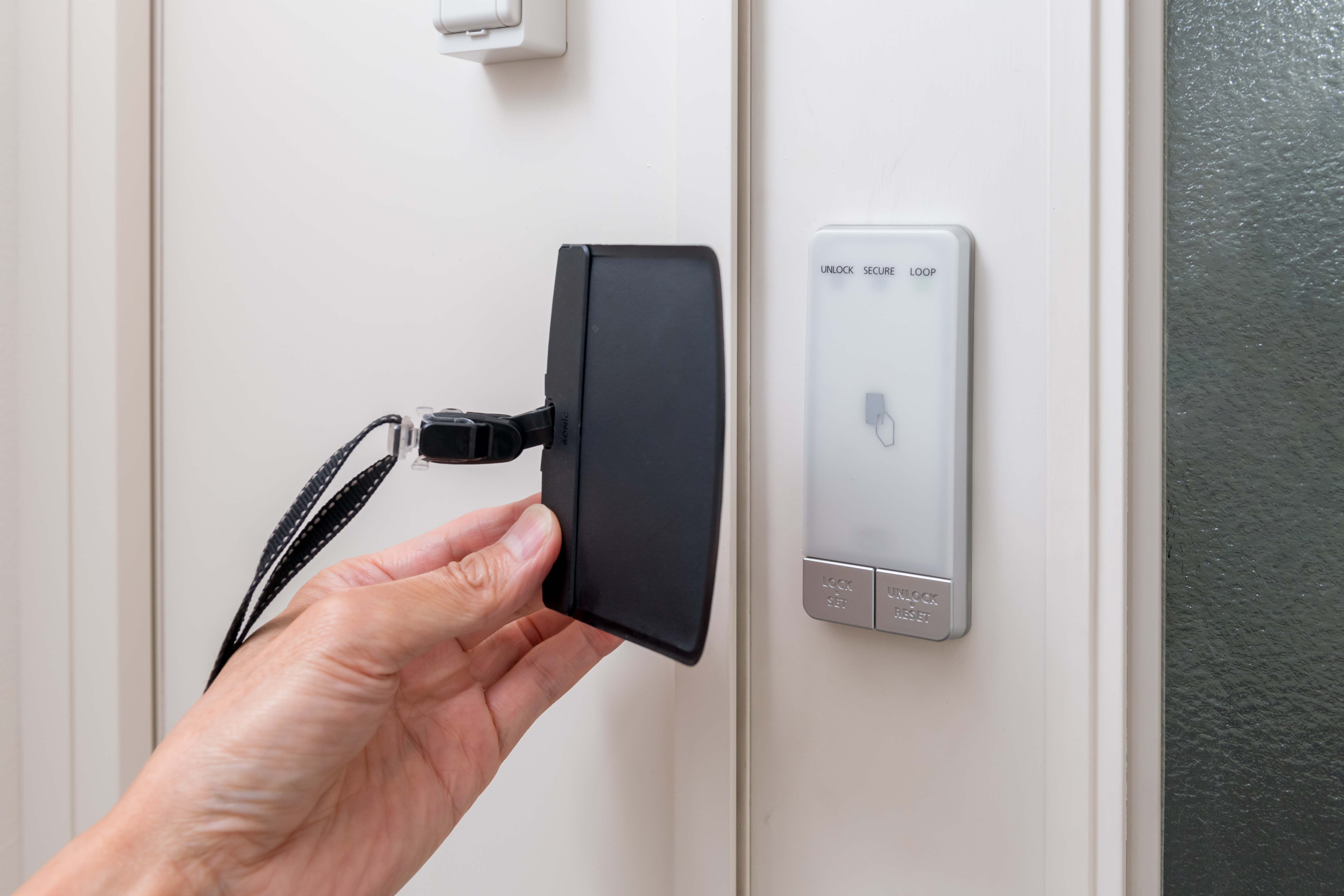 カードフォルダーに入ったICカードキーをかざす手